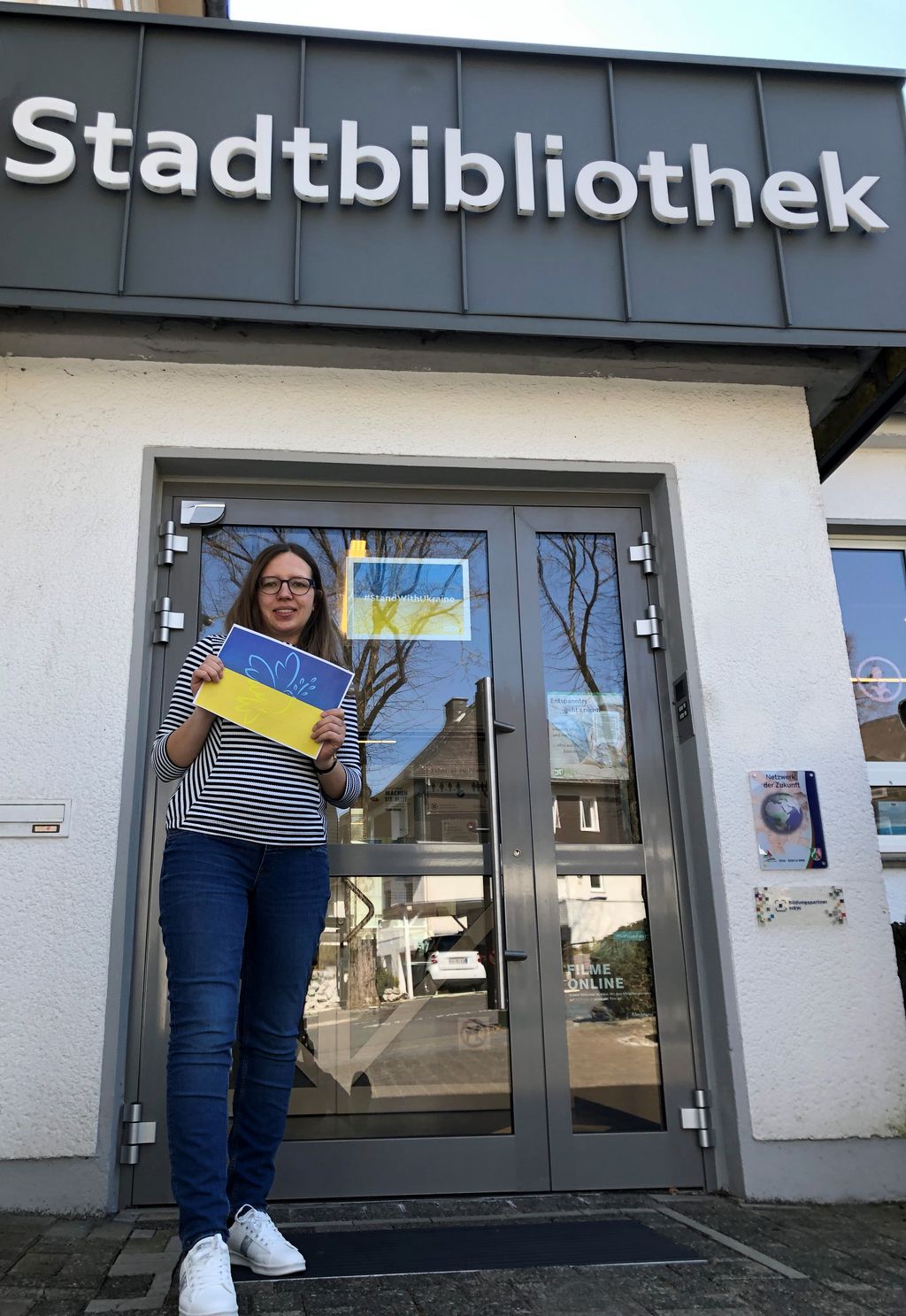 Christina Wegener (Team Bibliothek und Archiv) vor dem Eingang der Stadtbibliothek Brilon