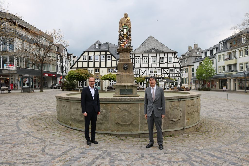 Bürgermeister Dr. Bartsch und der japanische Generalkonsul vor dem Petrusbrunnen