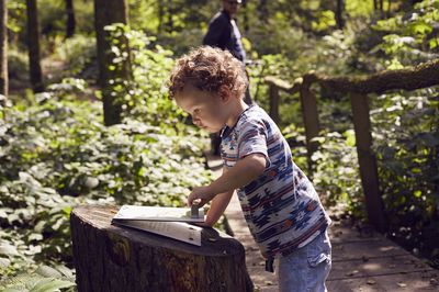 Kind an Lernstation im Wald