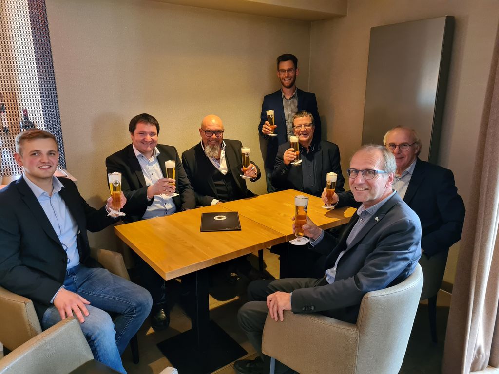 Die Vertragspartner stoßen nach der erfolgten Vertragsunterschrift mit einem Warsteiner an.
